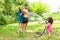 Parents play with little daughter outdoors