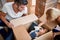 Parents playing with their daughter hiding in cardboard box.  new apartment, new beginning, joy, playful, carefree, leisure