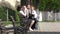 Parents sitting on bench, mother rising up baby, father play with bigger child, happy family portrait in nature