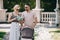 parents in sunglasses standing near baby carriage in park