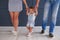 Parents teaching cute little daughter to walk in room