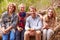 Parents and teenage kids eating outdoors in a forest, portrait