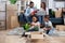 Parents with three kids sitting among boxes at new flat