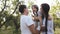 Parents tickling laughing girl in nature