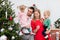 Parents with two children spend time by the Christmas tree