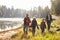 Parents and two children walking near a lake, close up