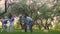 Parents and two daughters play sport with ball in spring park in the blooming garden. Active leisure.