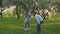 Parents and two daughters playing with ball in spring park in the blooming Orchard. Active leisure.