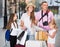 Parents with two kids traveling together searching location on paper map