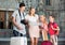 Parents with two kids traveling together searching location on paper map