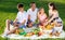 Parents with two teenagers enjoying  delicious meal on the picnic