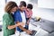 Parents using laptop with son in kitchen