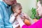 Parents using the nasal aspirator to clear the mucus from the nose of their infant.