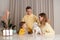 Parents in yellow sweaters, mother and father with child son and white dog, three abstract plastic bottles on the table