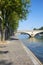 Paris, empty Seine river docks with trees and bridge in a sunny summer day