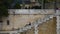 Paris, France - 3 May 2023. Remote view of young bearded man in casual clothes sitting on steps of city promenade. Side