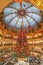 Paris, France - December 15: Massive Christmas tree decoration with flowers inside Galerie Layfayette shopping mall