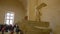 Paris, France - March 31, 2019: People on stairs look at The Winged Victory of Samothrace.