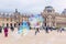 PARIS, FRANCE - MAY 09, 2019: View of glass Pyramid and Louvre Museum through multi-colored soap bubbles of street entertaining,