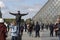 PARIS, FRANCE. people posing in front of the entrance of The Louvre under the crystal pyramid