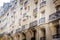 Paris old building with straight and round balconies, awnings, stucco