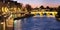 Paris, panorama along Seine river towards illuminated Pont Neuf