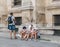 Paris tourist family sits on sidewalk studying maps