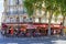 Paris, typical cafe brasserie with sidewalk tables with people and tourists sitting in a sunny day