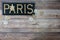 Paris word in brass letters on black painted wood