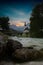 The parish church of St. Sebastian in Ramsau near Berchtesgaden as a long exposure with the river and a bridge at sunset