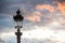 Parisian lamppost against clouds at sunset