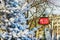 Parisian metro sign with trees covered with snow