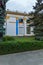 Park alley with neatly clipped green bushes near a beautiful building with ornamental decorative moldings