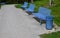 Park benches in light blue made of metal strips similar to a lattice. trash can and beautiful lawn with park paths of gravel thres