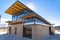 Park building with flat roof and brick wall under blue sky and bright sun