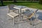 Park furniture chess table and chairs for four persons made of light metal and wooden beams with backrest on bright glade area gra