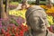 Park landscape with sand stone doll with colorful flowers in the background.