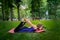 In the park, a little girl bends back, clutching her legs, performs yoga elements, does stretching