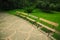 Park promenade alley way for walking with paved road and empty wooden benches summer calm day time weather without people here