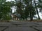 Park with tree silhouettes in the evening, the pedestrian walking path, old and damaged road surface plate