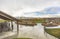 Park with view of vast cloudy sky over snow peaked mountain and homes