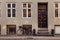 parked bicycle with basket near grey building with closed doors on street