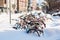 Parked bicycles covered in snow after heavy snowfall.