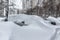 Parked cars sunk under the snow after a heavy snow storm