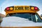 Parked front end of a school bus with the windshield covered with snow after a storm