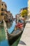 Parked gondola waiting for tourists at side canal in Venice