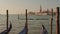 Parked gondolas on Piazza San Marco and The Doge\'s Palace embankment with the bell tower of the Saint Giorgio Maggiore