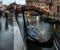 Parked gondolas at side canal at rainy day in Venice