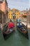 Parked gondolas waiting for tourists at side canal in Venice