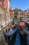 Parked gondolas waiting for tourists at side canal in Venice